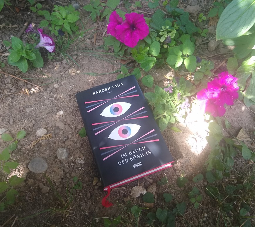 Buch "Im Bauch der Königin" im Blumenbeet